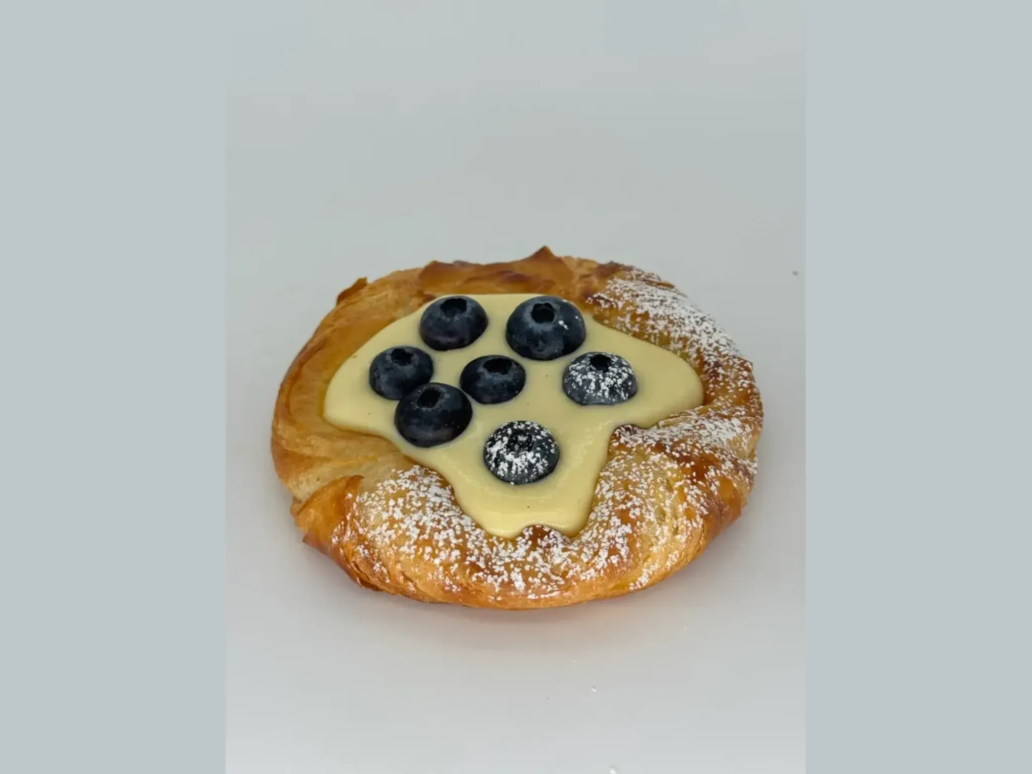 Crème Danish with Fresh Blueberries - Golden, flaky pastry topped with silky vanilla crème piped fresh after baking and crowned with juicy blueberries. Cool, creamy, and irresistibly fresh.