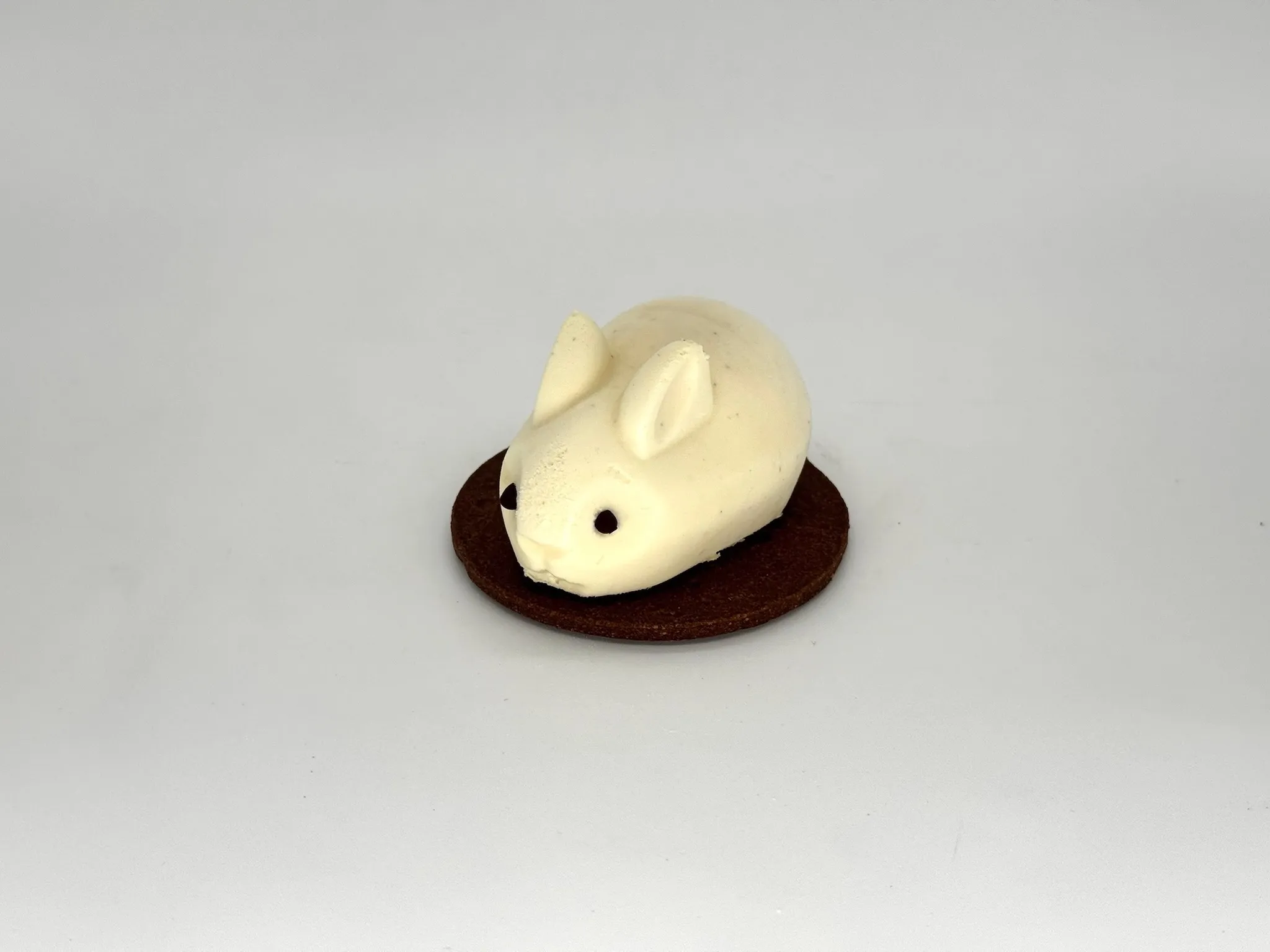 Tangerine Bunny Mousse Cake - Silky Madagascar vanilla mousse layered with bright tangerine confit and soft sponge cake, all resting on a crisp almond sable base. Creamy, citrusy, and perfectly balanced — playful in appearance, sophisticated in taste.